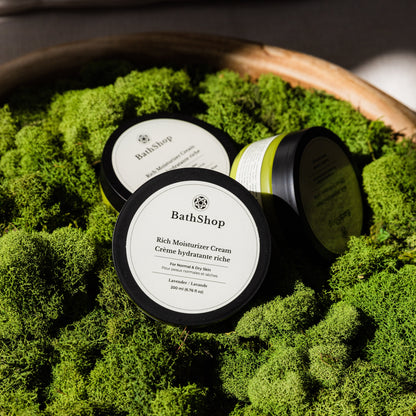 Plant-based moisturizer cream  from The Bath Shop on a bed of green moss in a wooden bowl.